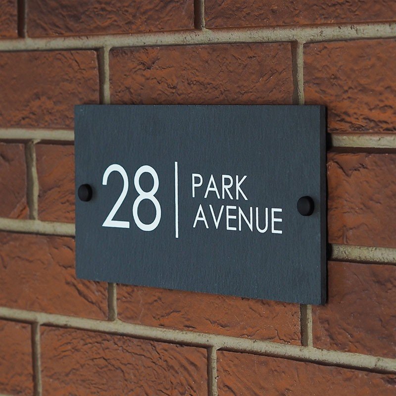 Lifestyle portrait showing a home entrance with Waymark slate sign installed